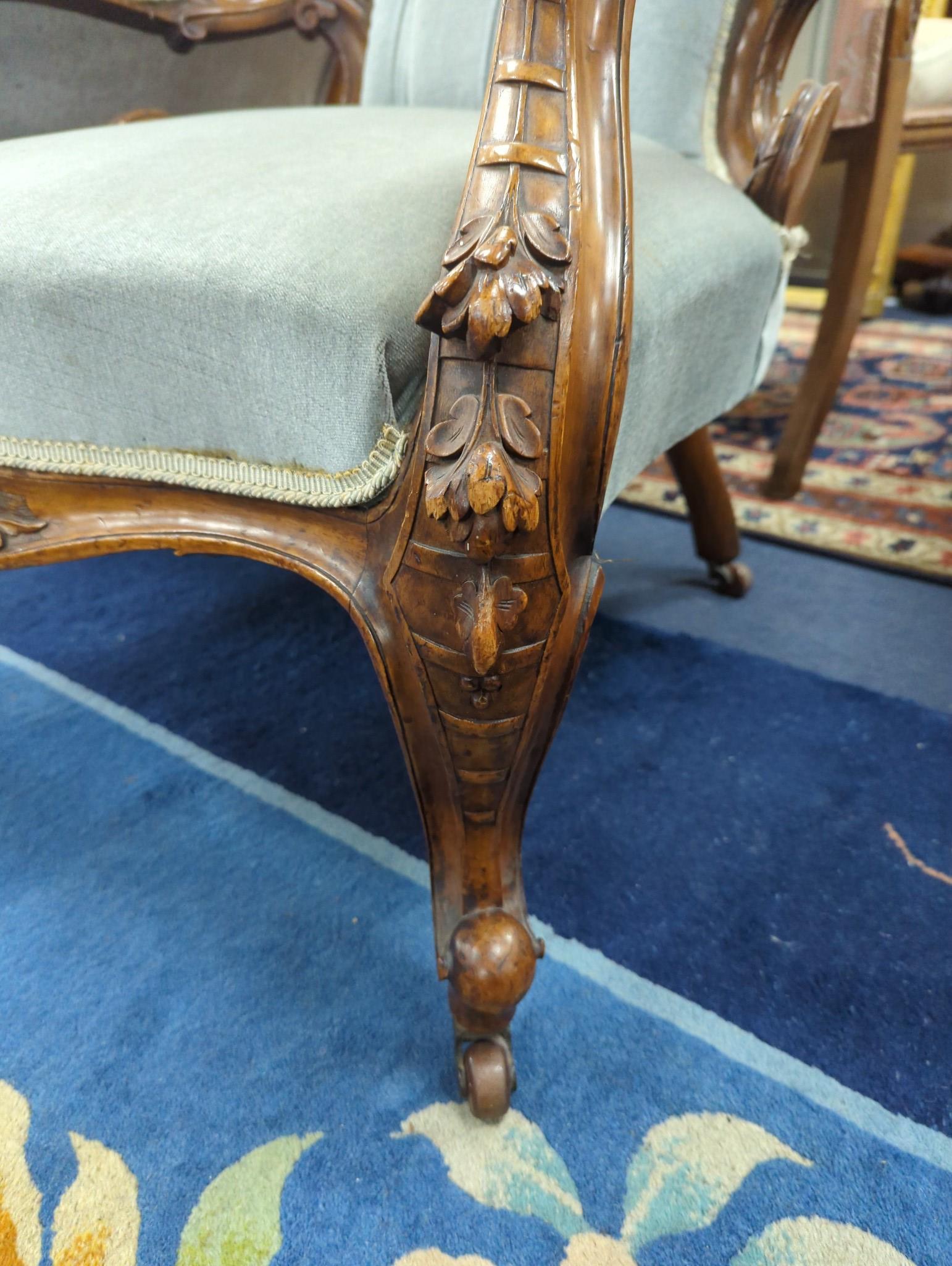 A Victorian carved walnut upholstered open armchair, width 68cm, depth 60cm, height 103cm